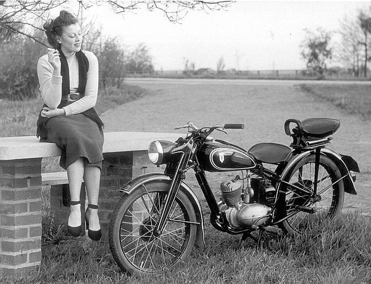 a man and a woman sitting on a motorcycle